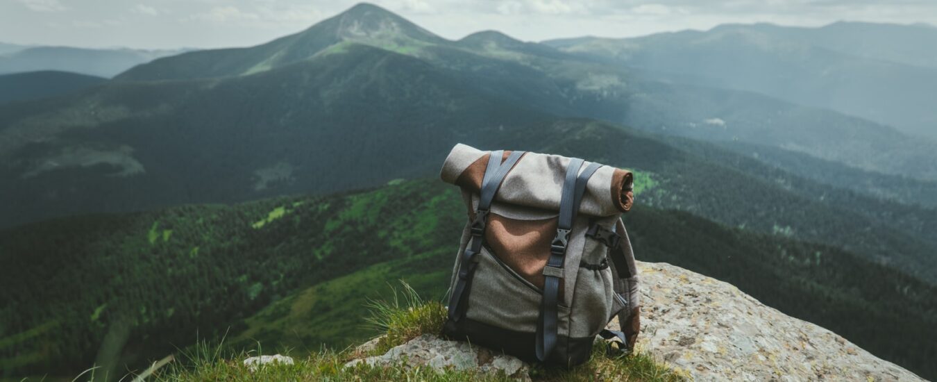 black and gray hiking backpack on green grass field during daytime